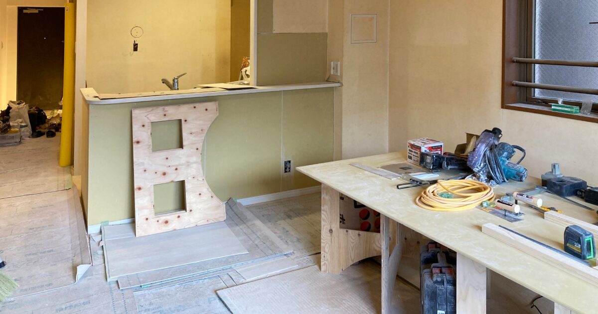リフォーム工事中の室内で作業台とカウンターを設置する施工現場