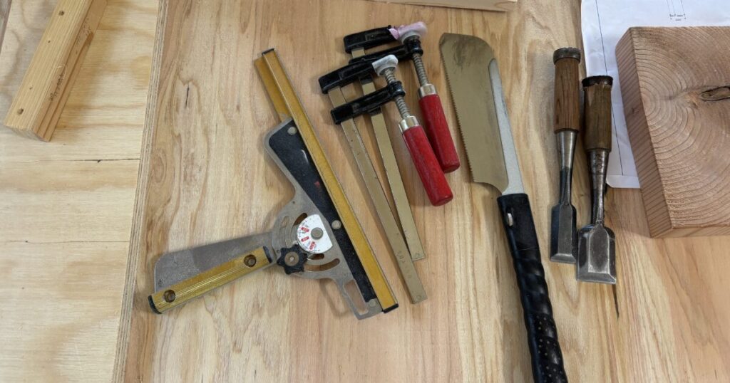 スコヤやノコギリとのみを並べた木工加工用の大工道具