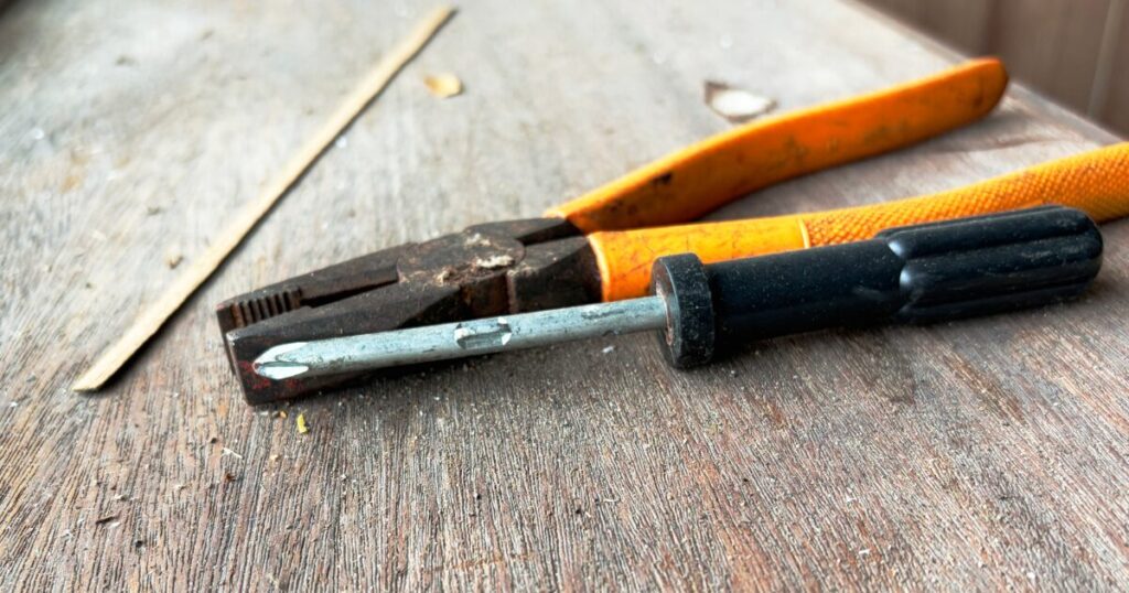 ドライバーとペンチを並べた修理作業用の手工具