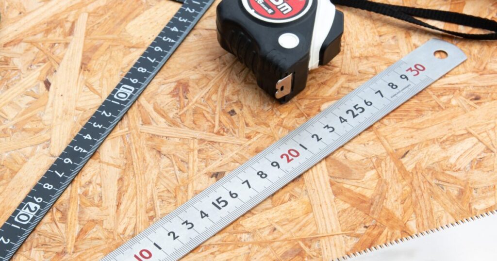 OSB合板の上に置かれたメジャーと定規による木工測定工具